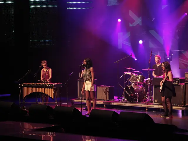 This picture shows four people performing on the dais with the help of a musical instruments and a...